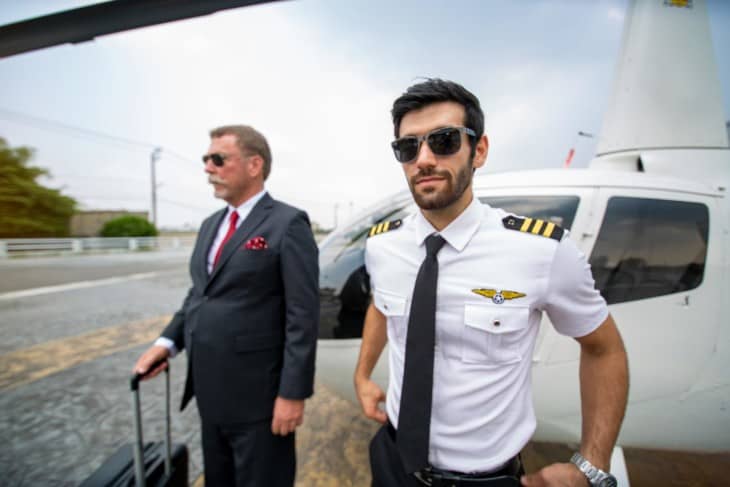 Business man and private helicopter pilot in front of helicopter