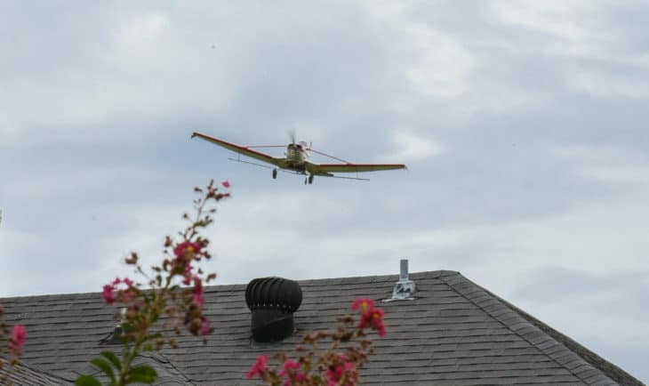 Crop duster over house